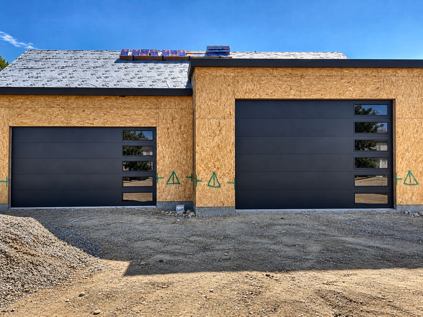 Two black modern garage doors on a new build