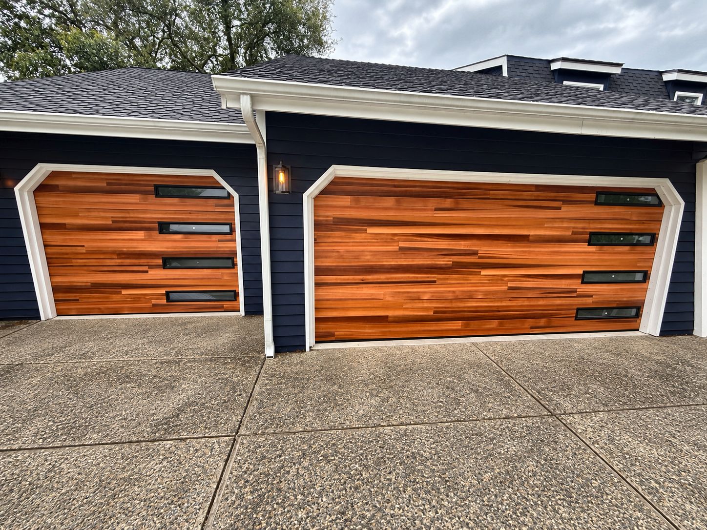 Two cedar garage doors with slim black windows