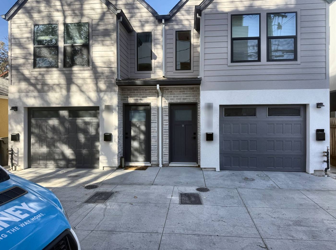 Two gray carriage-style garage doors on a duplex