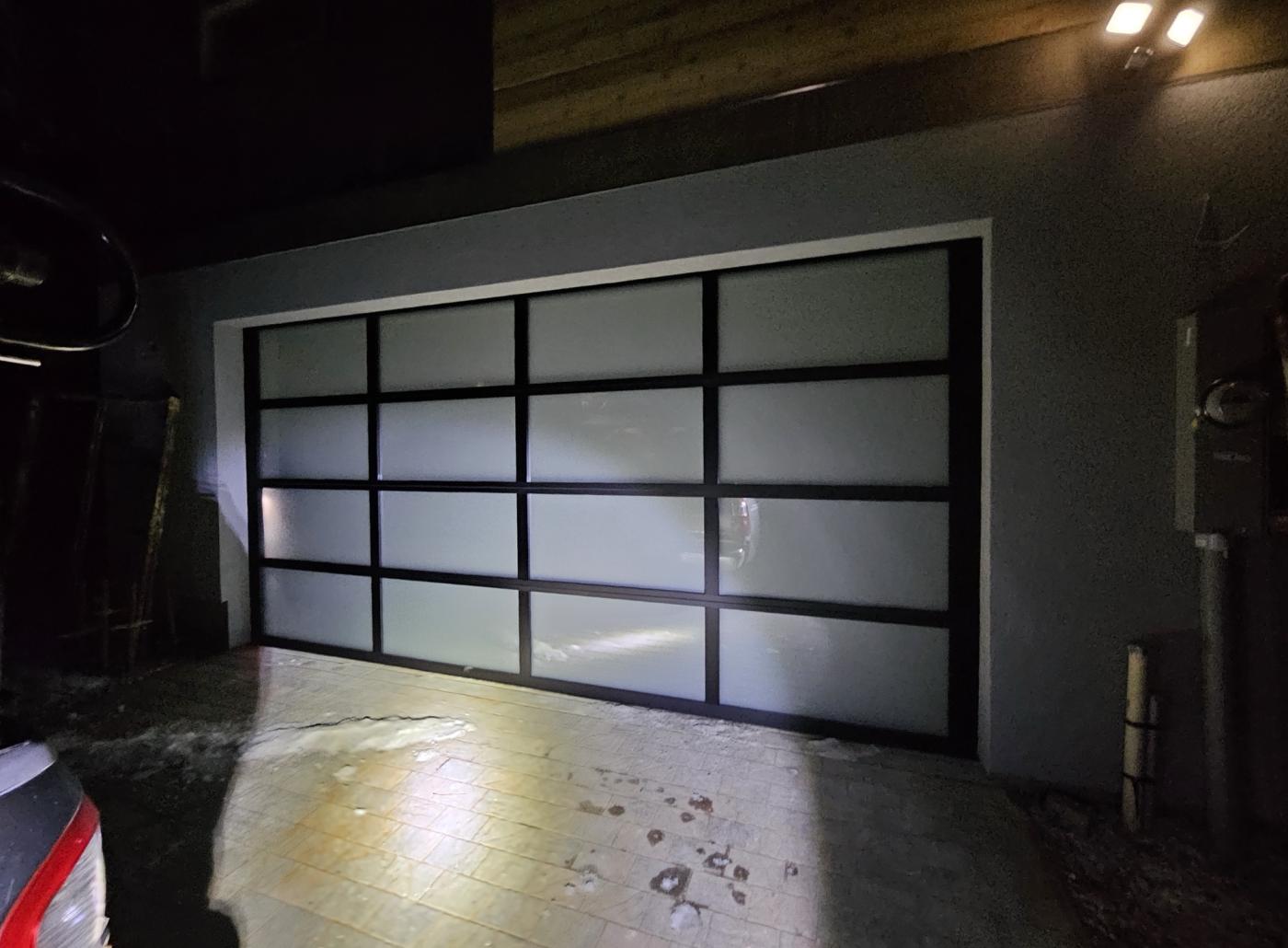 Full-view frosted glass garage door at night
