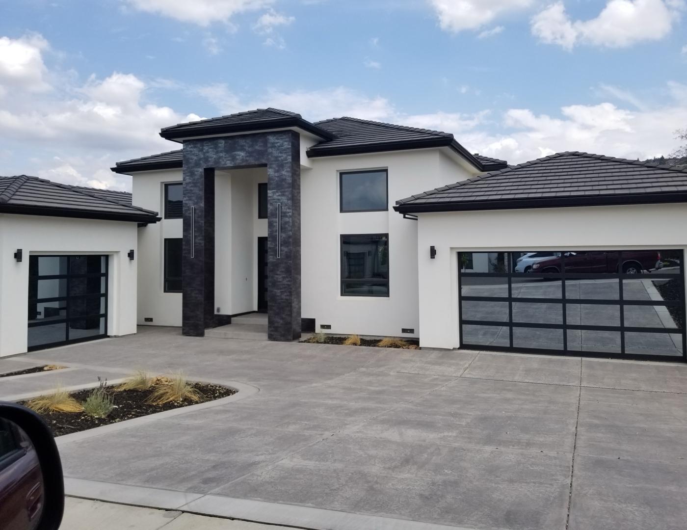 Full-view glass garage doors on a modern stucco home