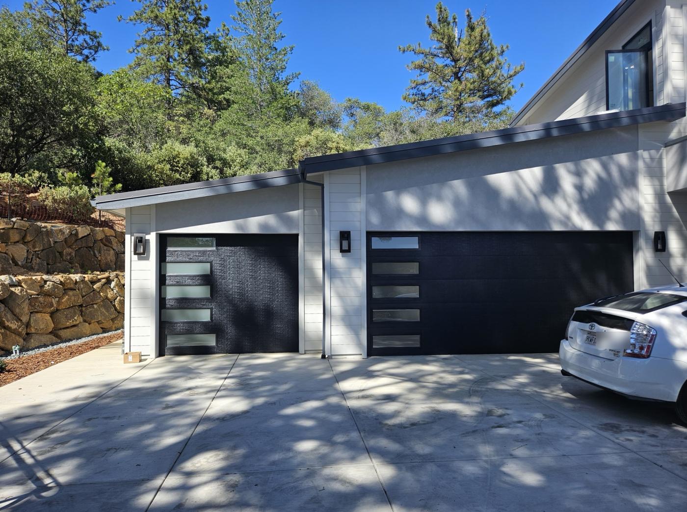 Two black flush garage doors with side windows