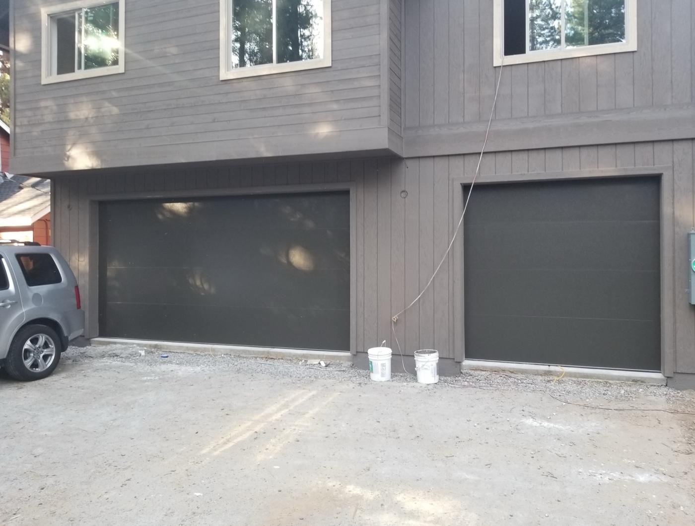 Two dark flush garage doors on a new build