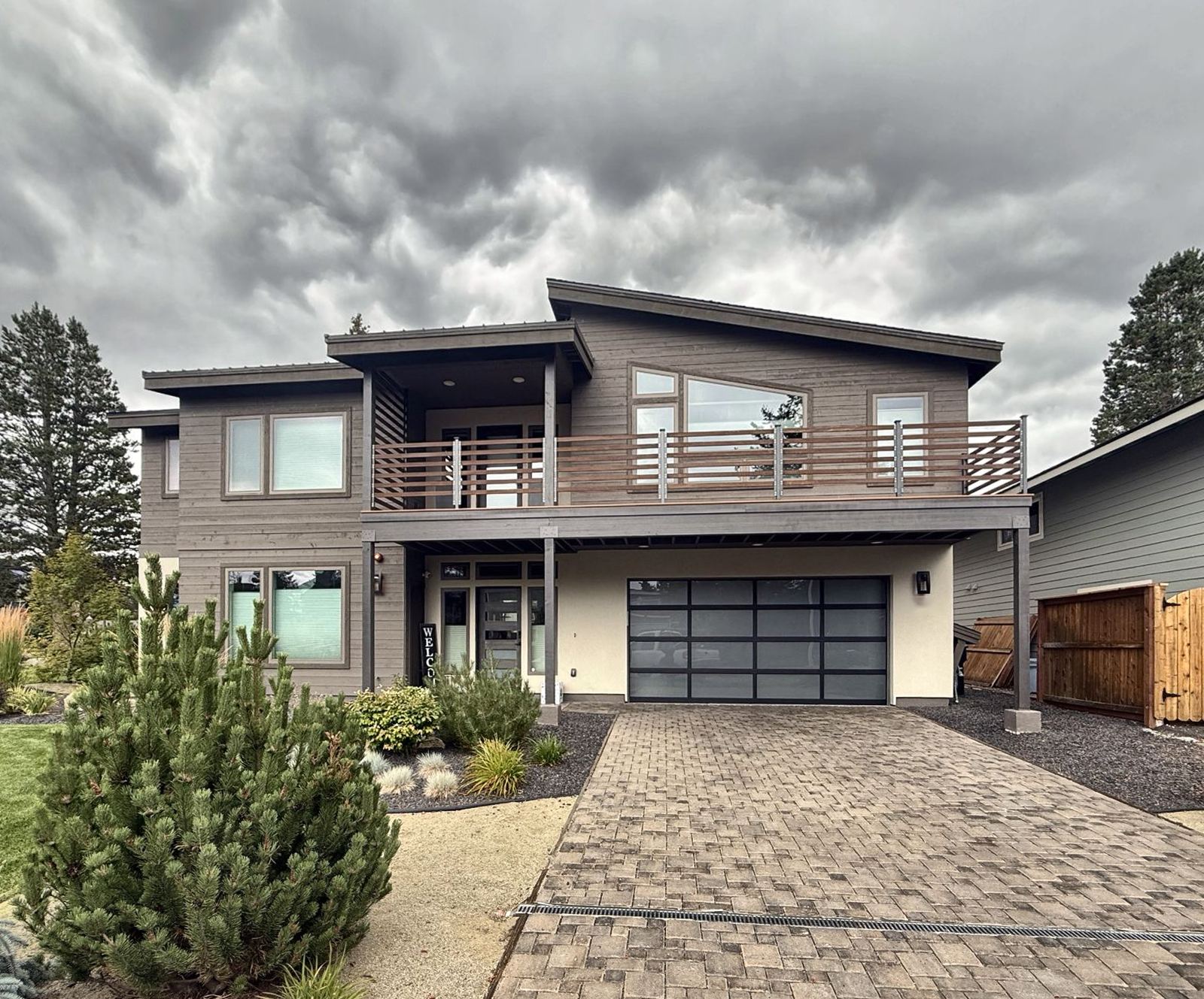 Two-story home with a black full-view glass garage door