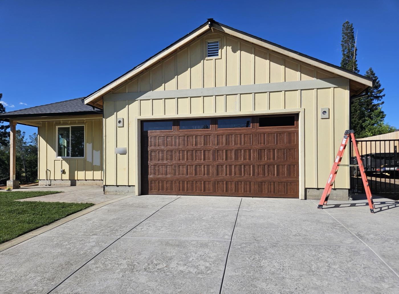 Woodgrain raised-panel double garage door with top windows