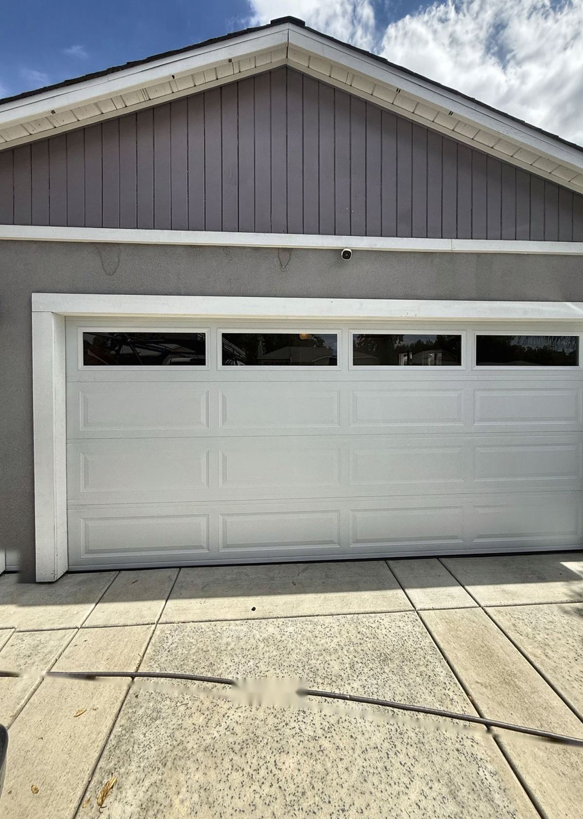White raised-panel garage door with top windows